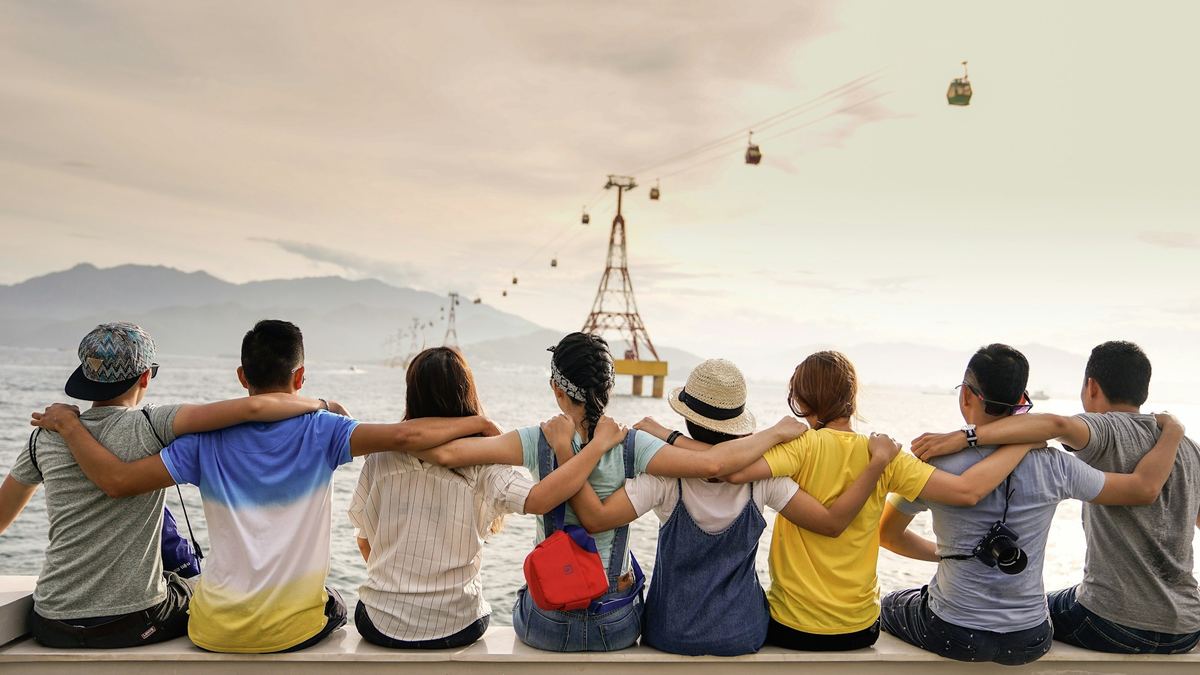 A group of friends sitting together, arms around each other's shoulders